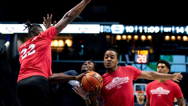 Former Xavier Musketeers player Nate Johnson (10) is fouled by former Cincinnati Bearcats player Troy Caupain Jr. (10) as former Cincinnati Bearcats player Corey DeBerry (22) attempts to block him during the Crosstown Collaborative Alumni Game at the Cintas Center in Cincinnati on Saturday, July 16, 2022. Crosstown Collaborative Fan Fest And Alumni Game 142
